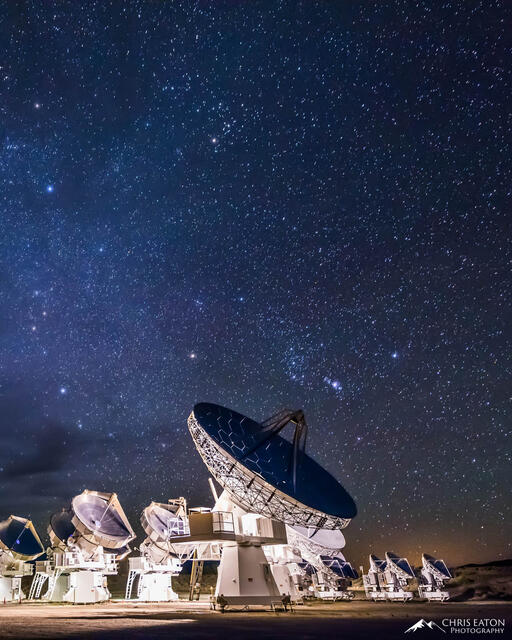 The constellation Orion hangs low in the night sky above the radio telescopes at CARMA (Combined Array for Research in Millimeter-wave Astronomy).