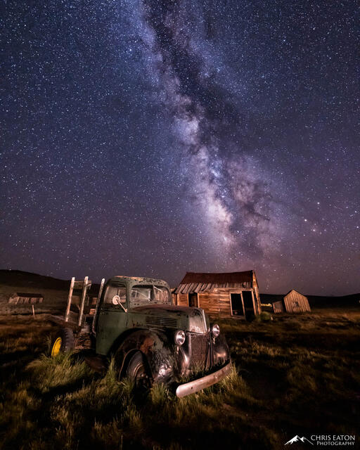 An old mining truck and ghost town with the Milky Way galaxy.