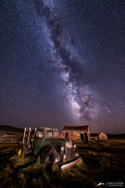An old mining truck and ghost town with the Milky Way galaxy.