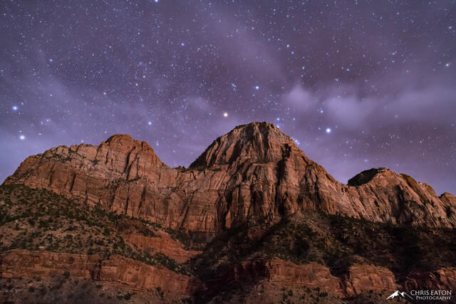 The constellation Orion begins to reveal itself from behind the cliffs in Zion National Park.