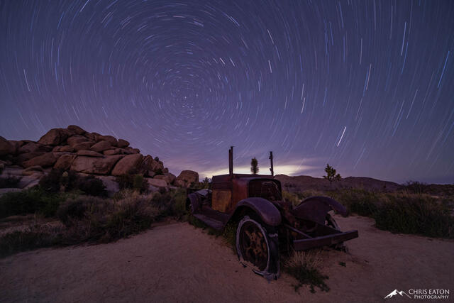 A long abandoned truck rusts away in the Mojave Desert landscape of Joshua Tree National Park as the star rotate around Polaris, the North Star.