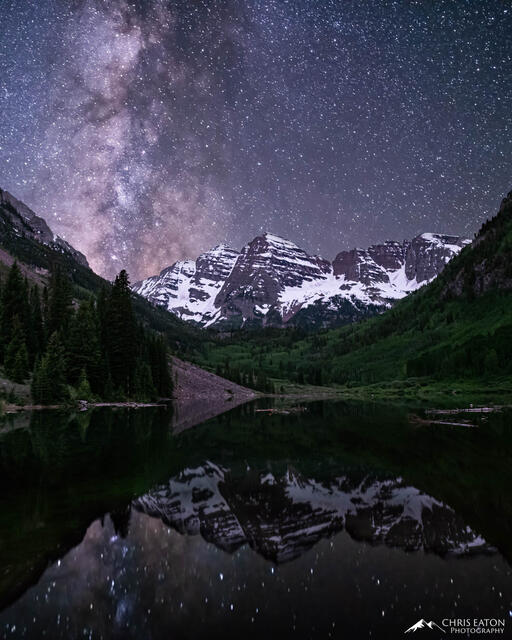 The Milky Way, our galaxy, rises over the Maroon Bells and Maroon Lake, where its reflection imprints the calm waters.