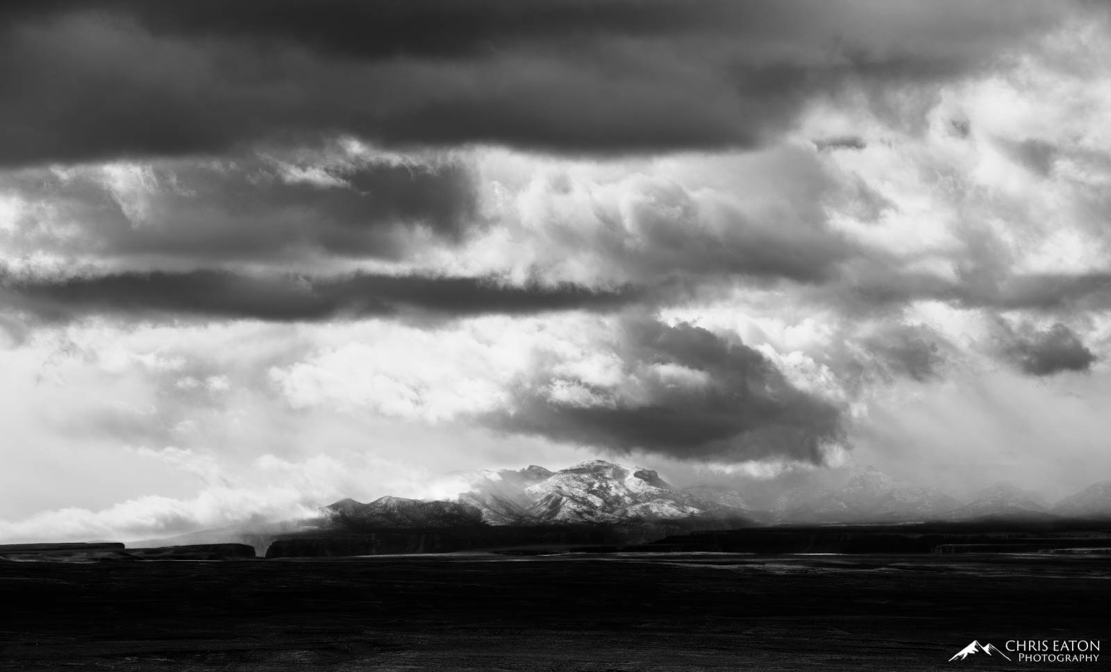 Break in the Storm During a Thanksgiving weekend storm, clouds part briefly to reveal the sunlit and snow covered bulge of the Kaibab Plateau as...