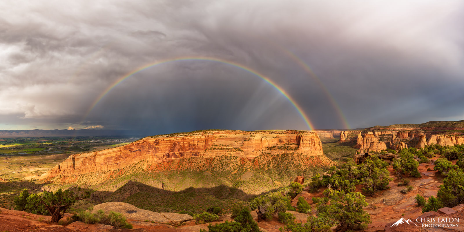 A post thunderstorm double rainbow arcs over Monument Mesa in Colorado Natrironal Monument.