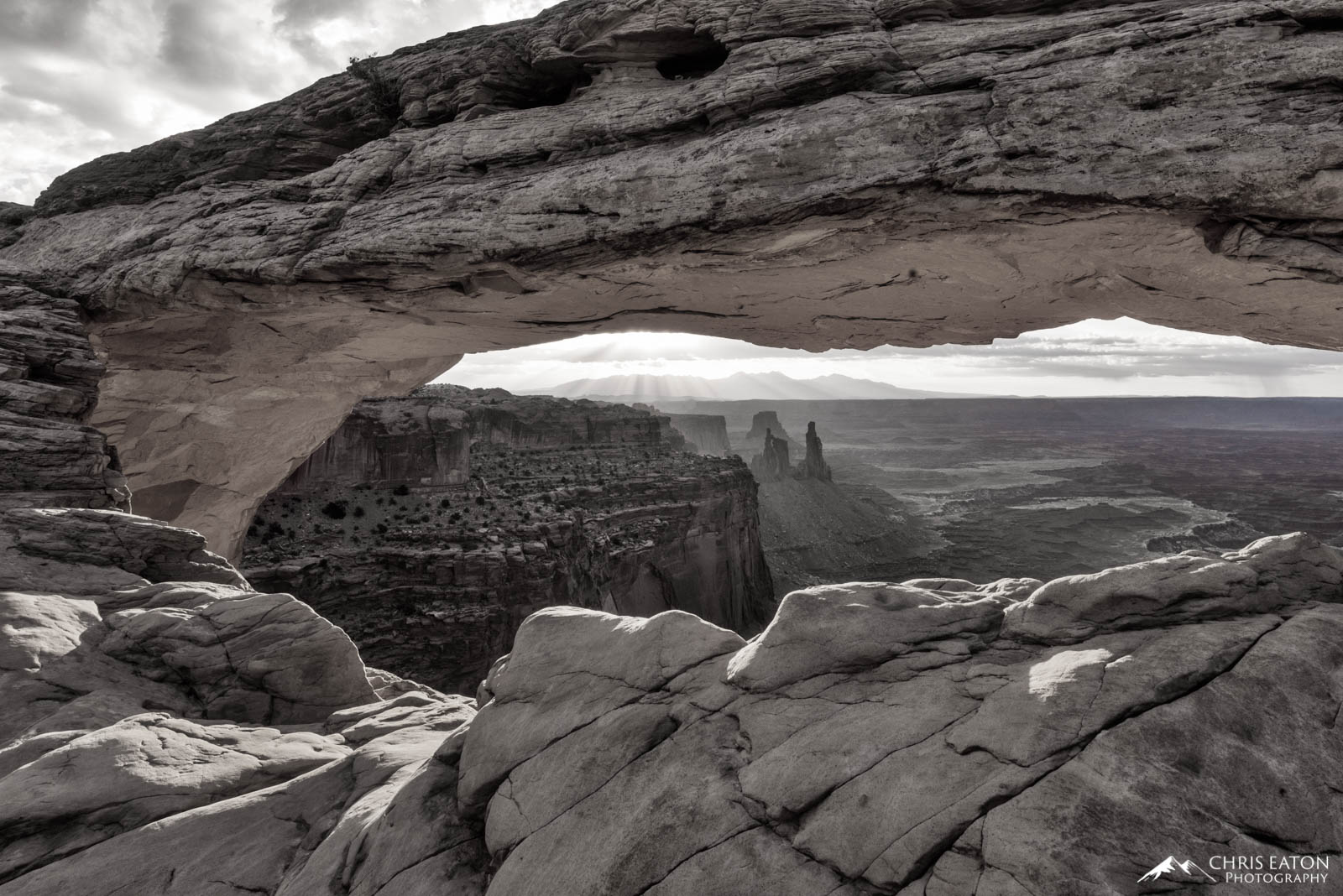 Window on the Morning Mesa Arch frames a window on the Canyonlands of the White Rim. Mesa Arch is a pothole arch formed when a regular pool of surface...