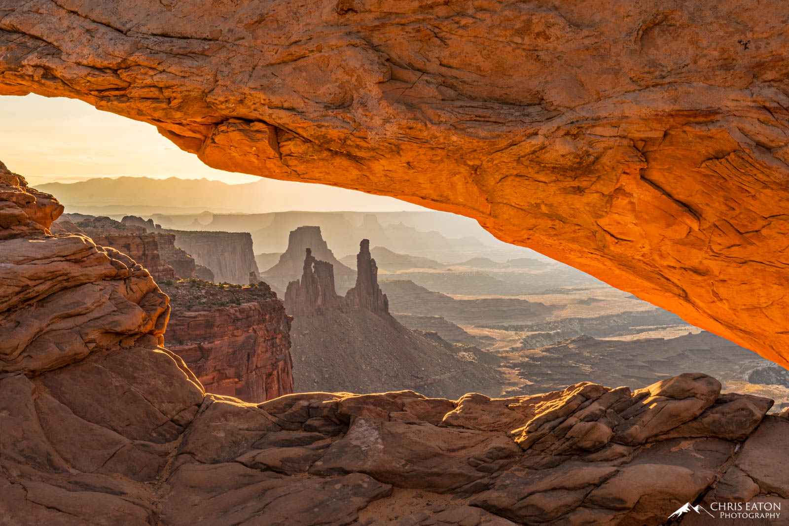 Washer Woman Arch and Monster Tower — fins of Wingate Sandstone below the Island in the Sky — bask in the early light of...