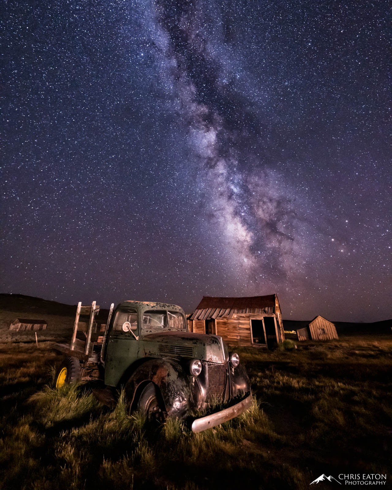 An old mining truck and ghost town with the Milky Way galaxy.
