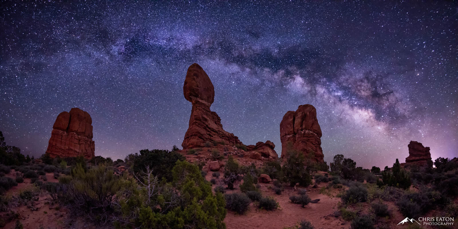 The Milky Way arches over Balanced Rock and nearby pillars of Entrada Sandstone in Arches National Park.