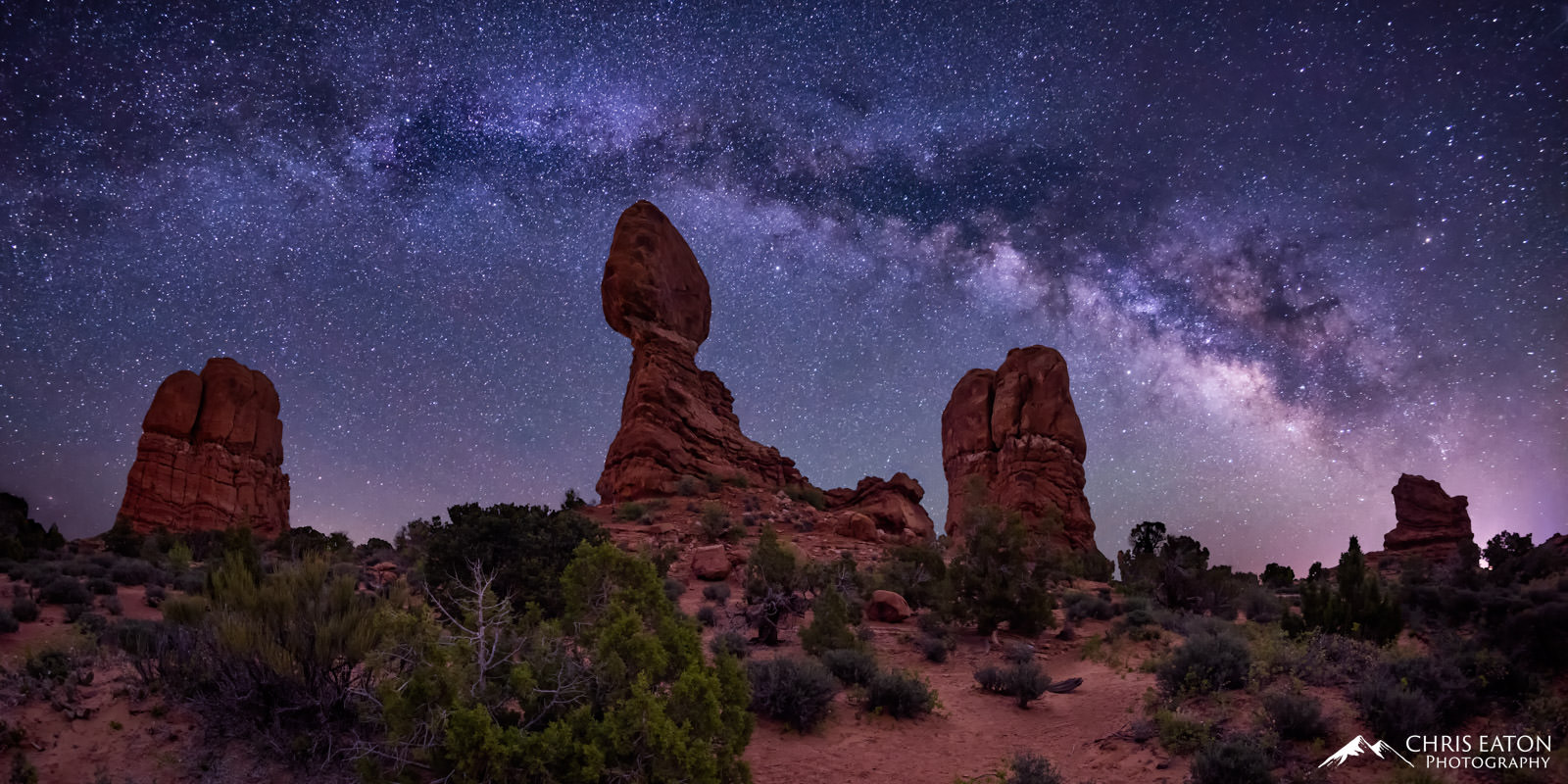 The Milky Way arches over Balanced Rock and nearby pillars of Entrada Sandstone in Arches National Park.