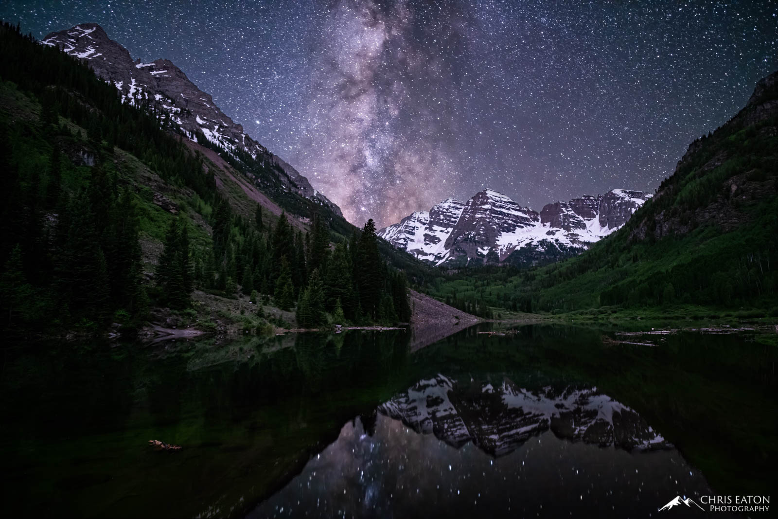 The Milky Way, our galaxy, rises over the Maroon Bells and Maroon Lake, where its reflection imprints the calm waters.