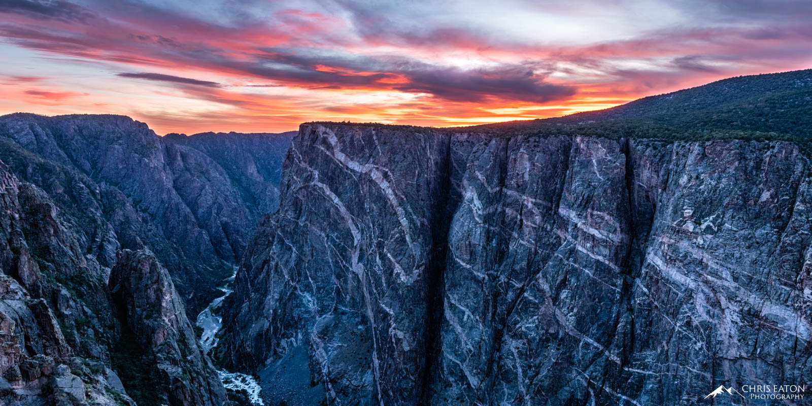 The receeding sunset paints the high clouds above the Painted Wall in Black Canyon oif the Gunnison National Park. The Painted...